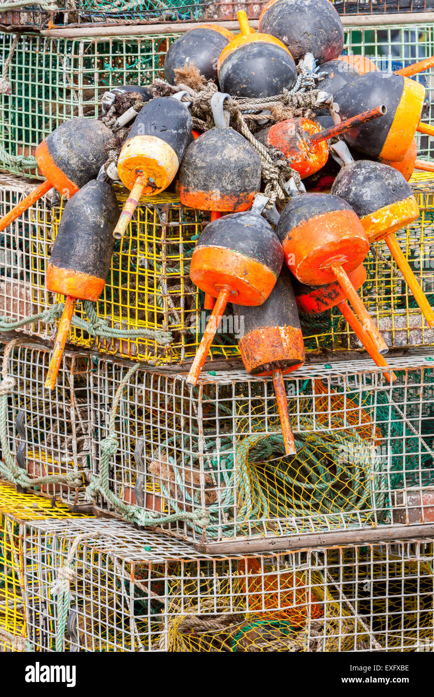 Les casiers à homard empilés et de bouées sur un quai dans le Maine. Banque D'Images