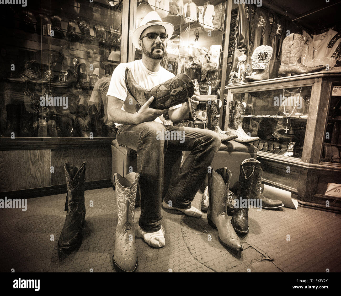 Man Trying on mexicain élégant bottes pointues dans un magasin à Oaxaca au Mexique Banque D'Images