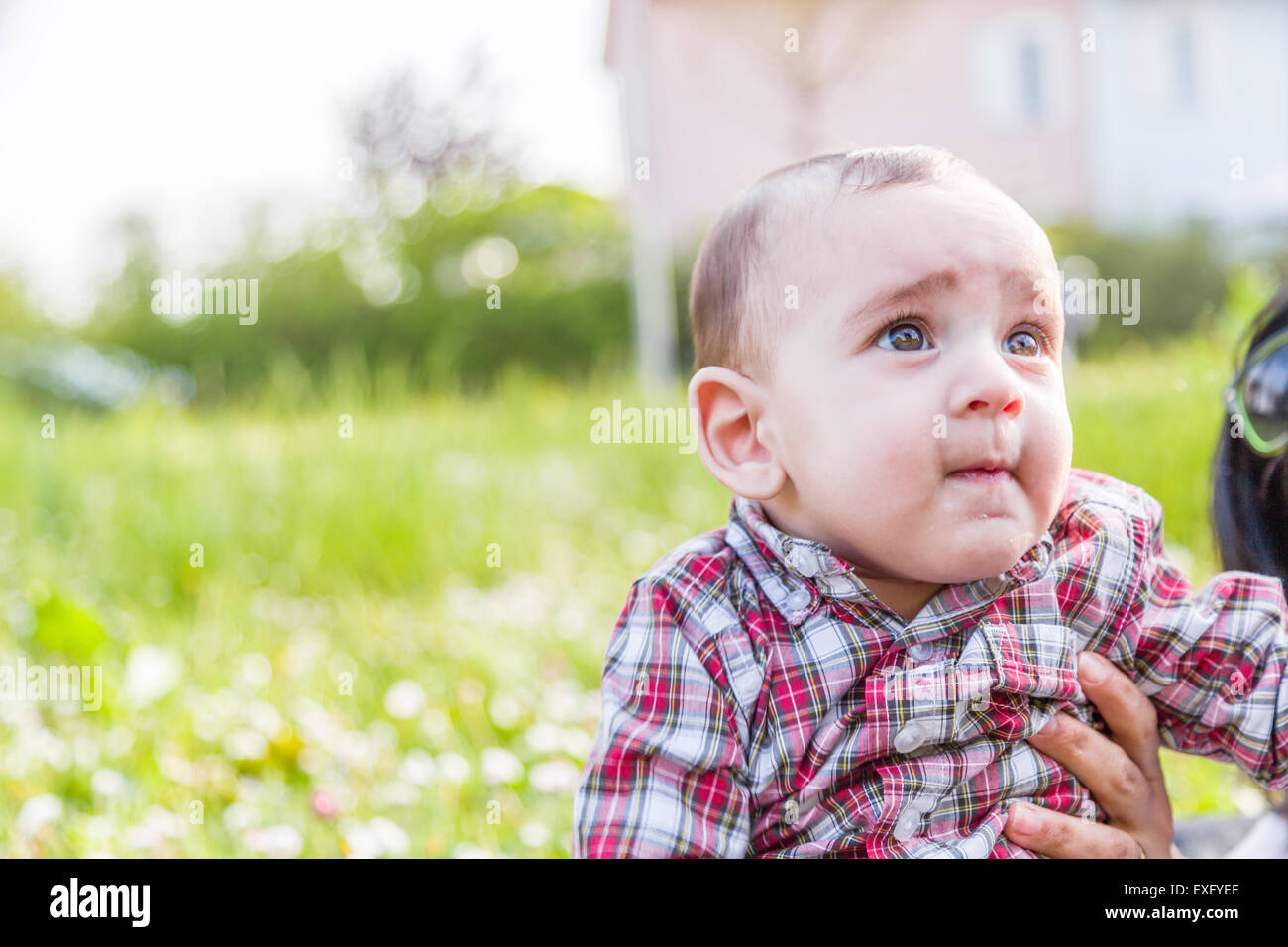 Mignon Bebe De 6 Mois Avec Les Cheveux Brun Clair A Rouge A Carreaux Chemise Et Pantalon Beige Est De Mordre Ses Levres Soufflant Ses Joues Et A La Mere Jusqu Alors Adoptee