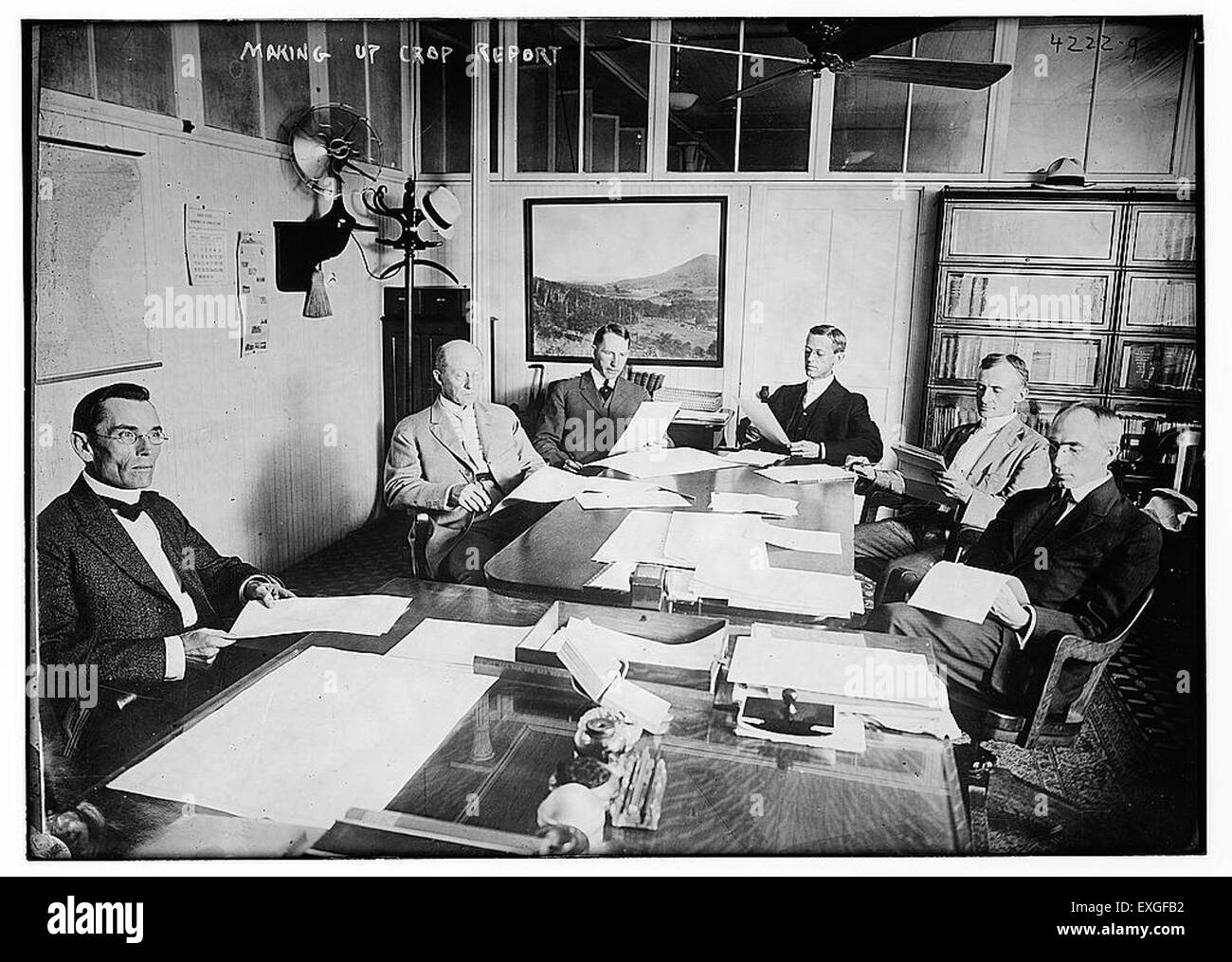 Cette image représente le processus de compilation d'un rapport de récolte, probablement à partir du début du XXe siècle. Les rapports sur les récoltes ont fourni des données essentielles pour l'agriculture, aidant les agriculteurs à suivre les rendements, les tendances météorologiques et les tendances du marché. Ce rapport a été un outil précieux pour la prise de décisions agricoles, influençant la production agricole et les stratégies économiques dans les communautés agricoles. Banque D'Images