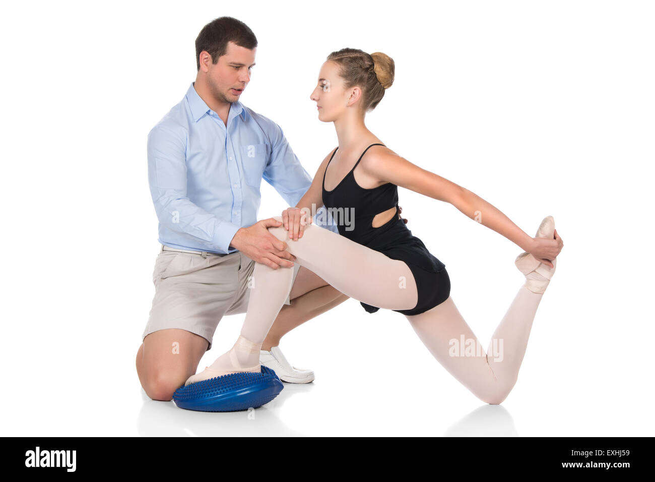 Belle femme danseuse de ballet et son physiothérapeute isolé sur un fond blanc. Ballerine est vêtu d'un justaucorps noir, poi Banque D'Images