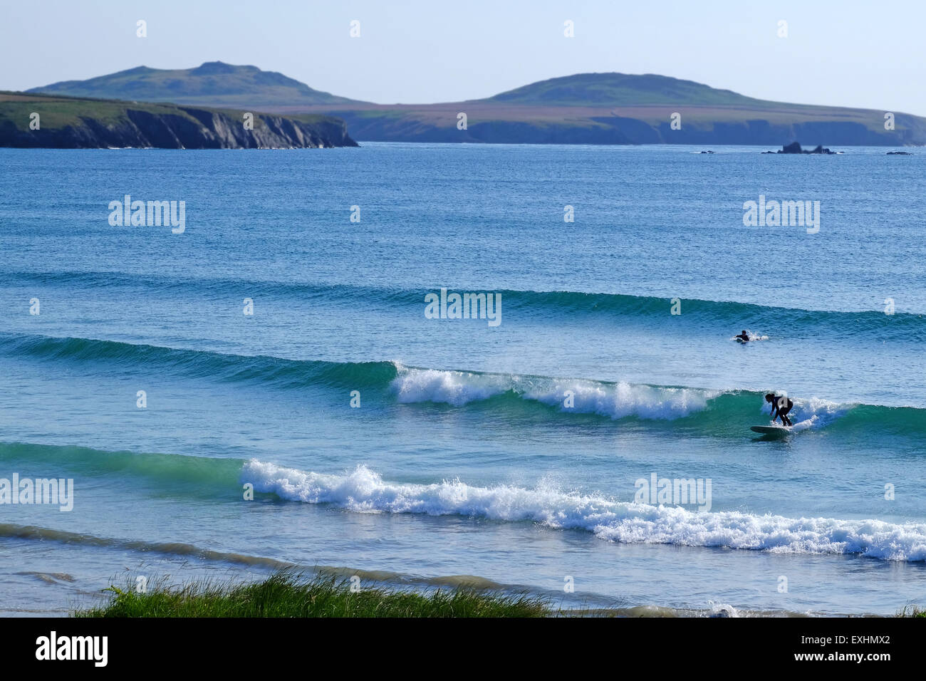 Le surf au Whitesands beach près de St Davids dans la région de Pembrokeshire, Pays de Galles, avec l'ouest de l'île de Ramsey dans la distance. Banque D'Images