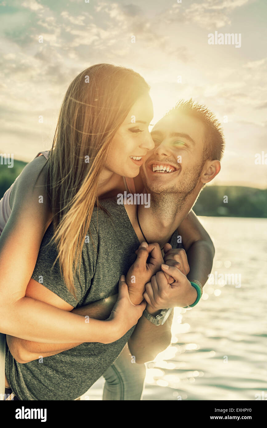 Couple in love embrassant au bord du lac, sun flare Banque D'Images