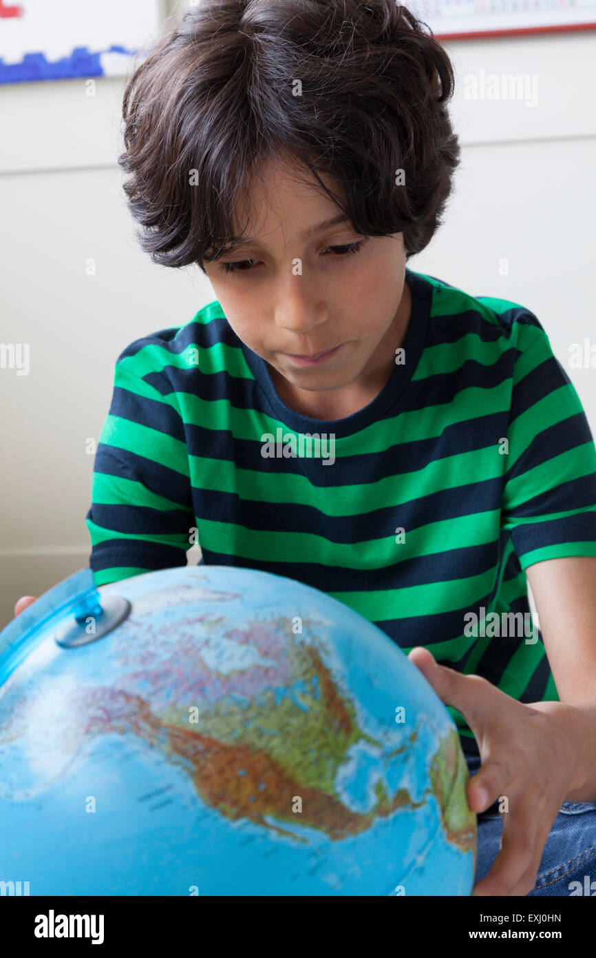 Teenage boy looking at globe en plastique Banque D'Images