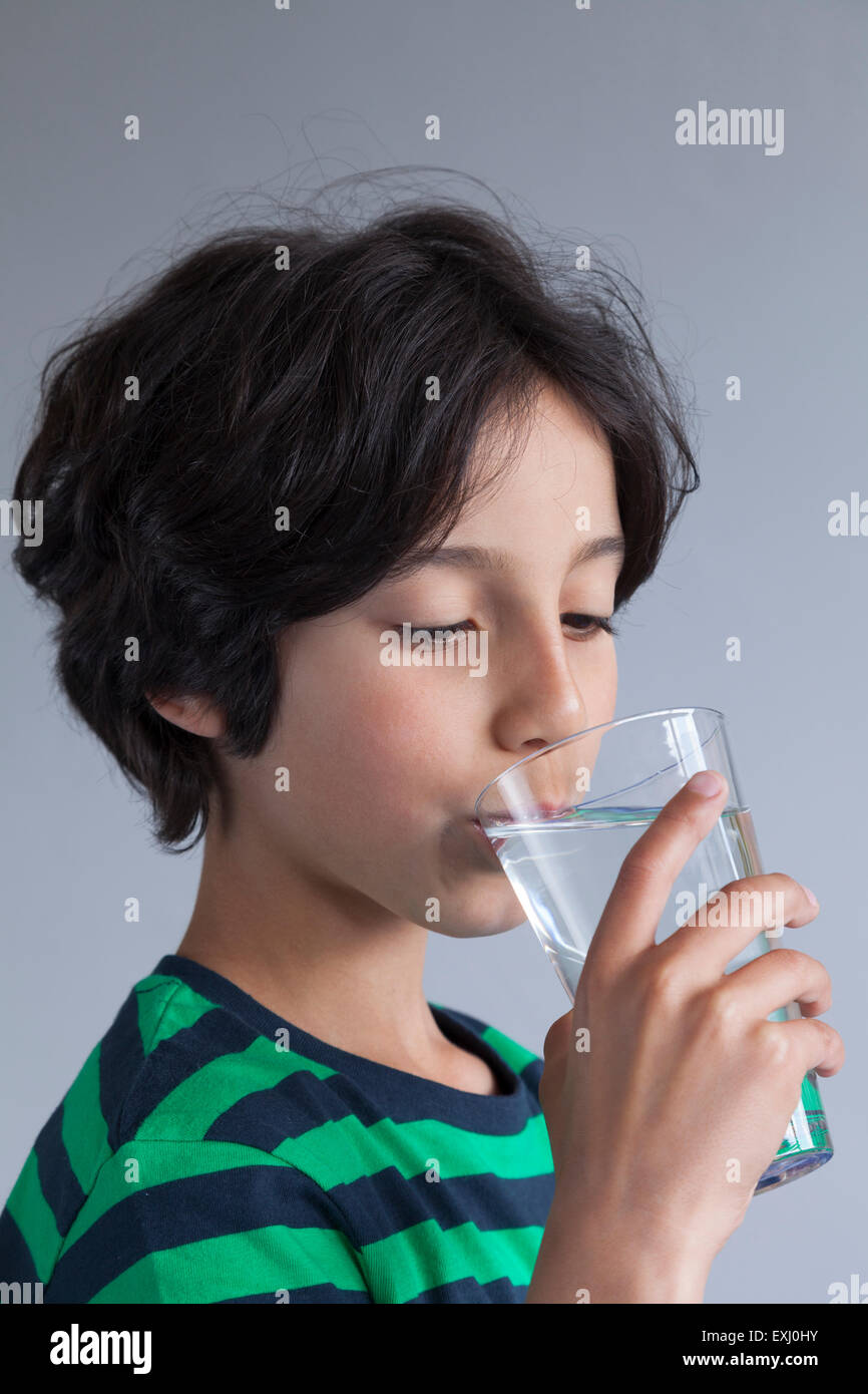 Teenage boy boire un verre d'eau Banque D'Images