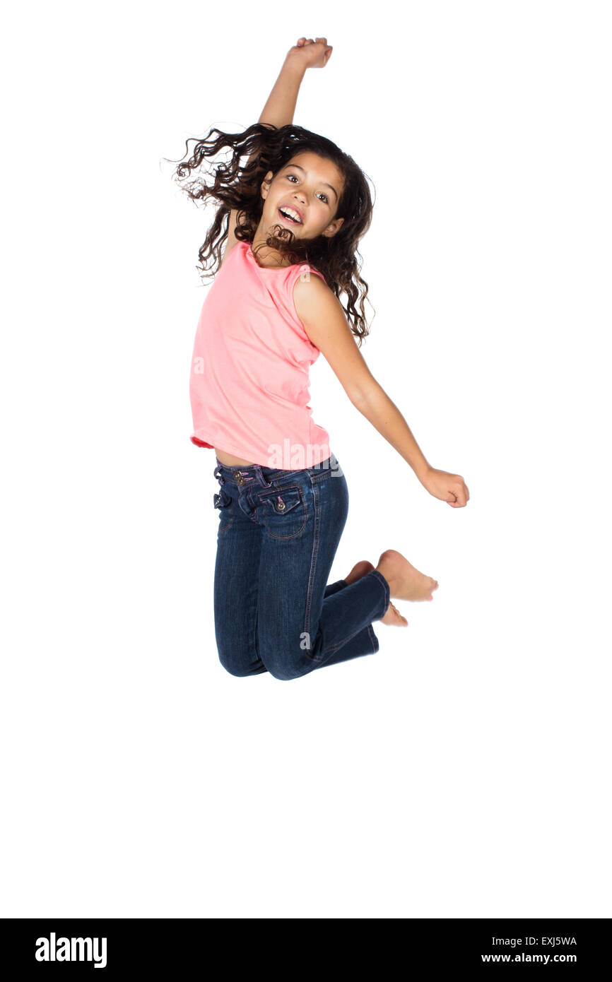Pretty cute young girl wearing a haut rose et un jean bleu. La jeune fille saute et souriant. Banque D'Images