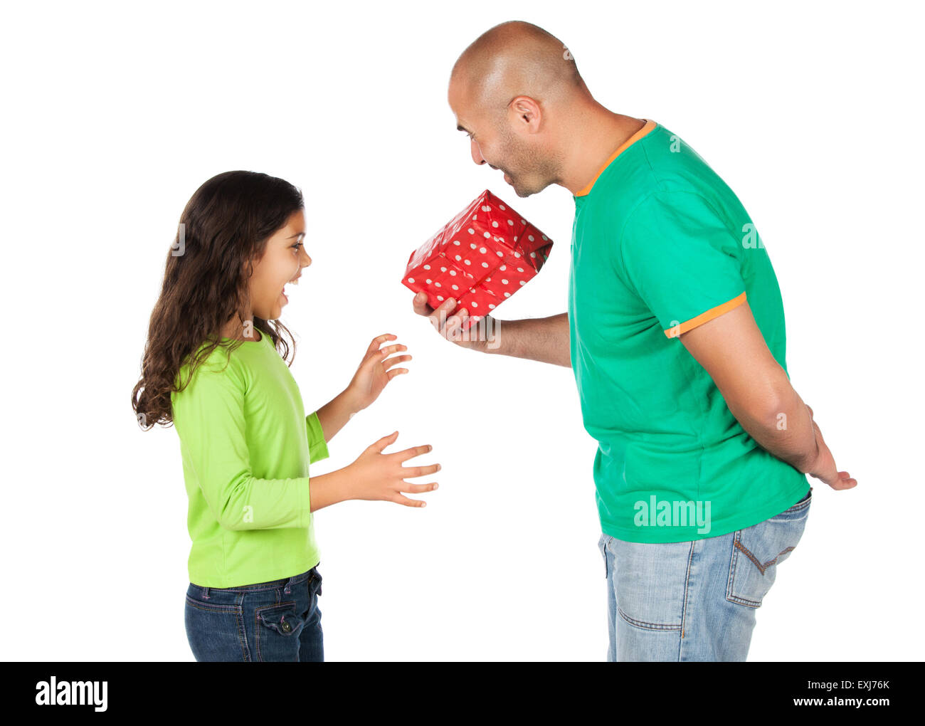 Pretty cute young girl wearing a green et blue-jeans et son père. Il donne lui un cadeau en rouge wrappin Banque D'Images