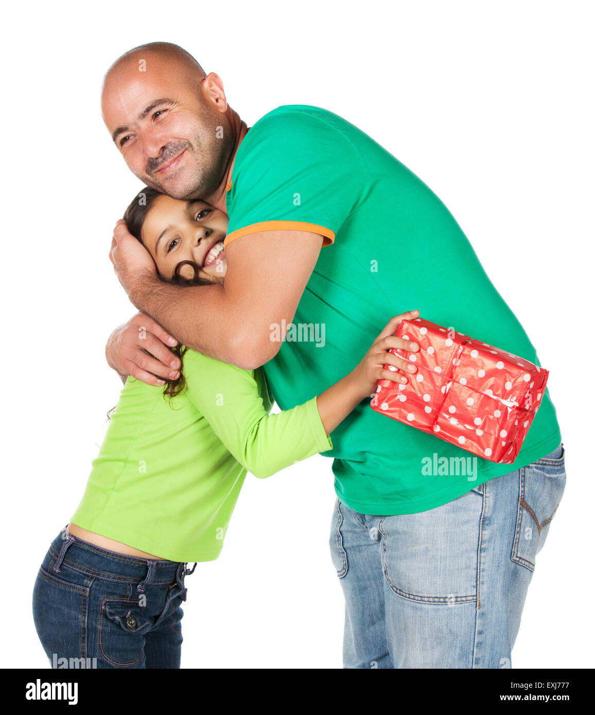 Pretty cute young girl wearing a green et blue-jeans et son père. Il donne lui un cadeau en rouge wrappin Banque D'Images