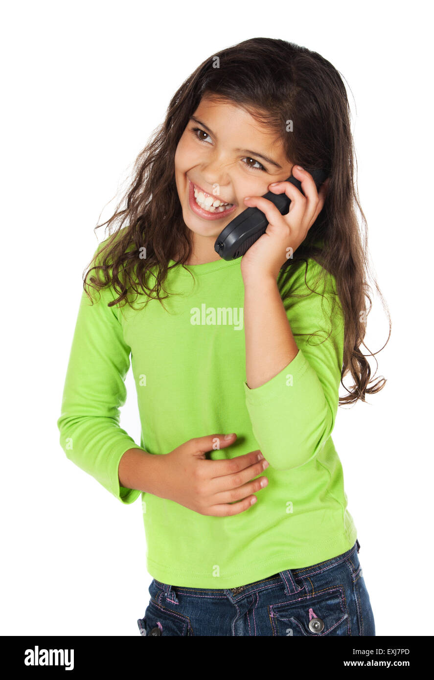 Pretty cute young girl wearing a green top et un jean bleu. Elle est en train de parler sur un téléphone mobile. Banque D'Images