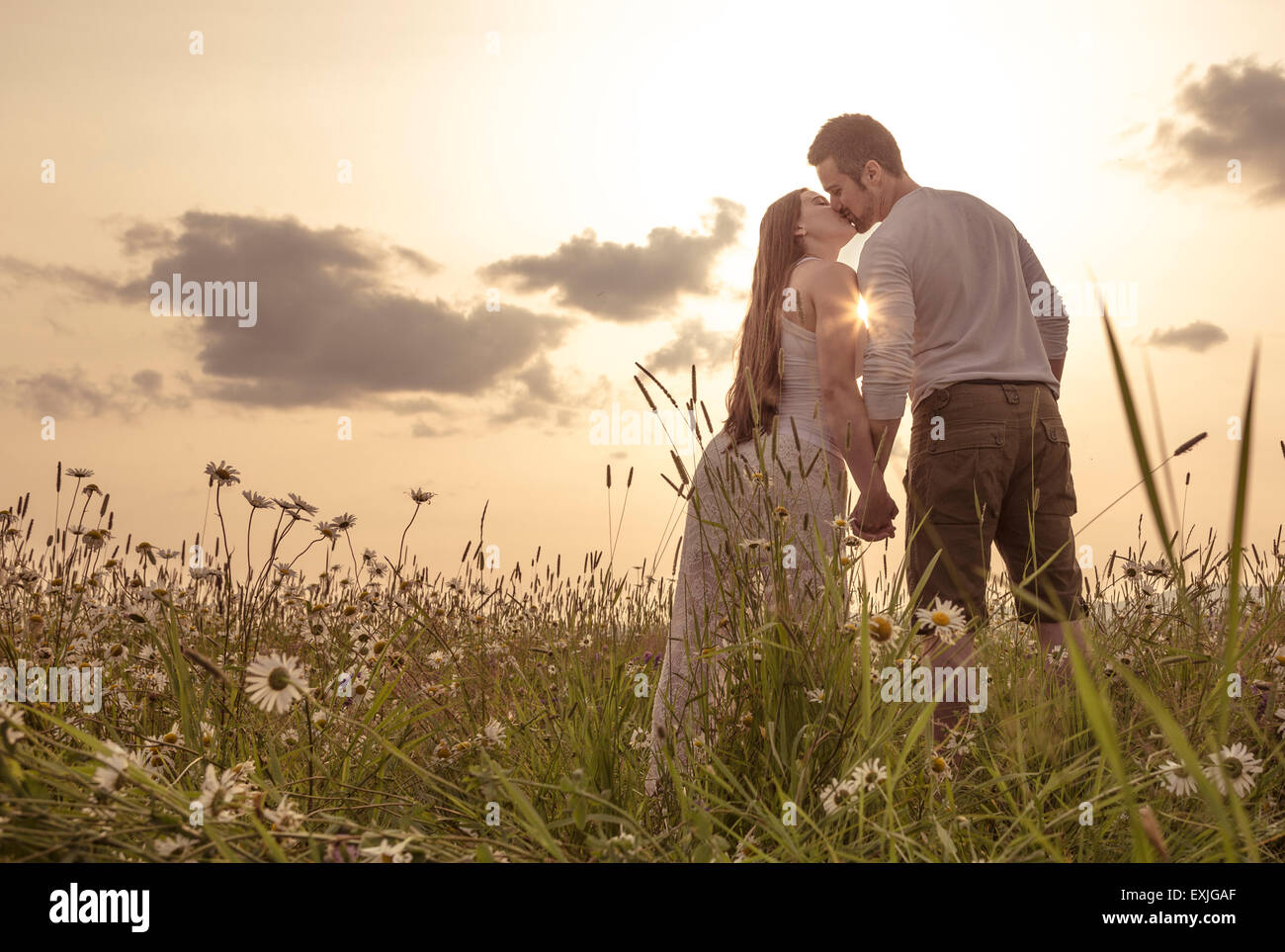 Jeune couple amoureux piscine au coucher du soleil Banque D'Images