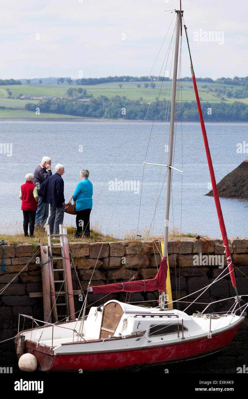 Groupe de personnes âgées personnes debout sur le mur du port, Charlestown, Fife Banque D'Images
