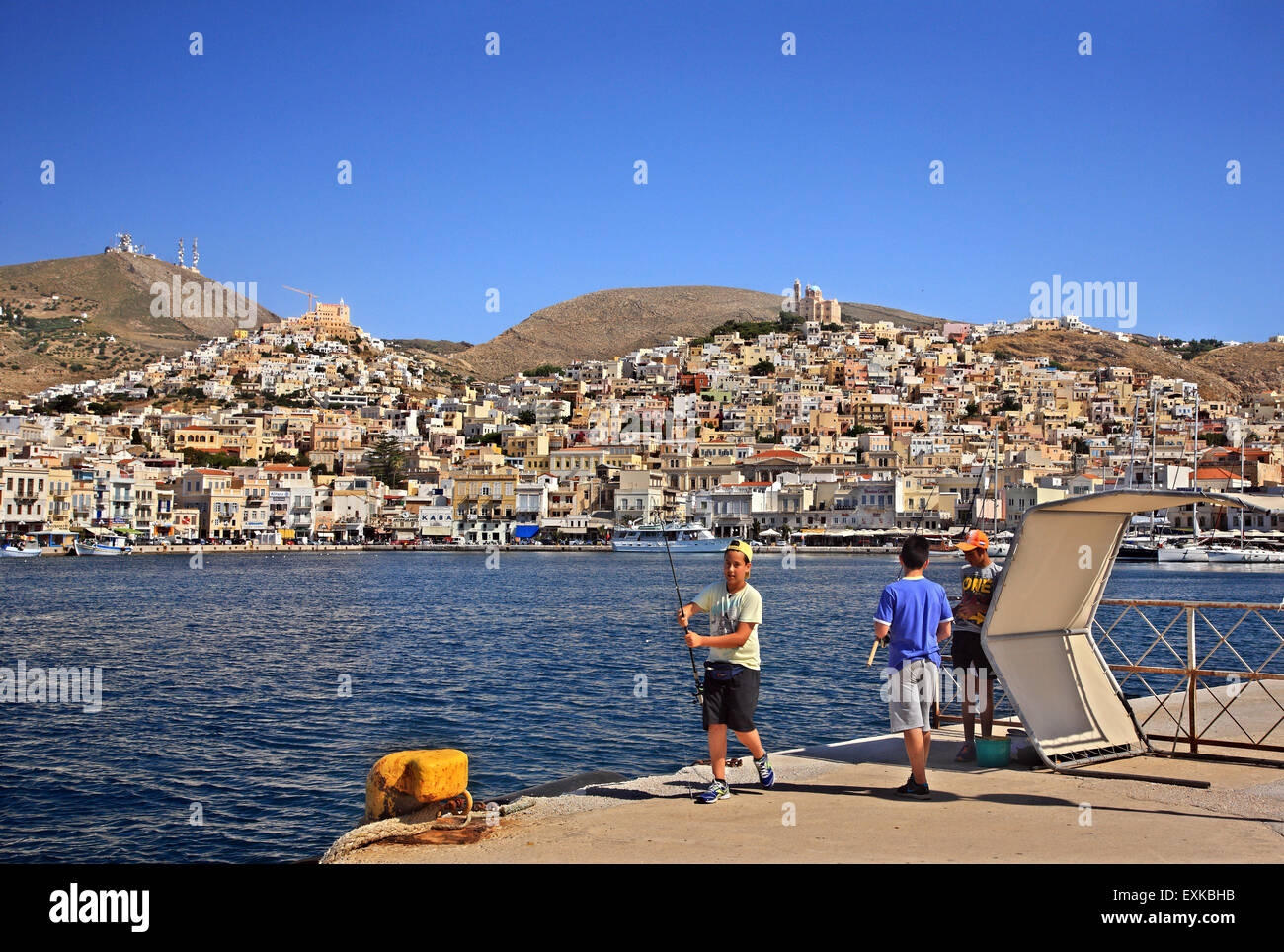 Les enfants pêcher au port d'Ermoupolis, l'île de Syros, Cyclades, Mer Égée, Grèce. Banque D'Images