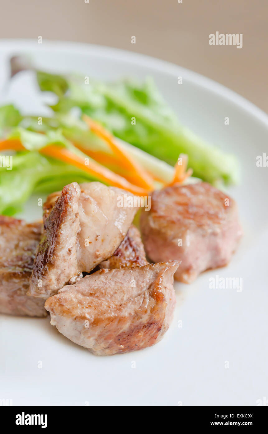 La viande de porc grillée avec salade fraîche sur une plaque Banque D'Images