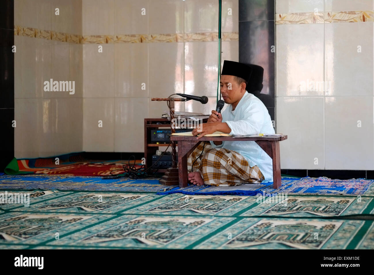 Homme de la région de lecture du Coran dans une petite mosquée du village durant le ramadan java indonésie Banque D'Images