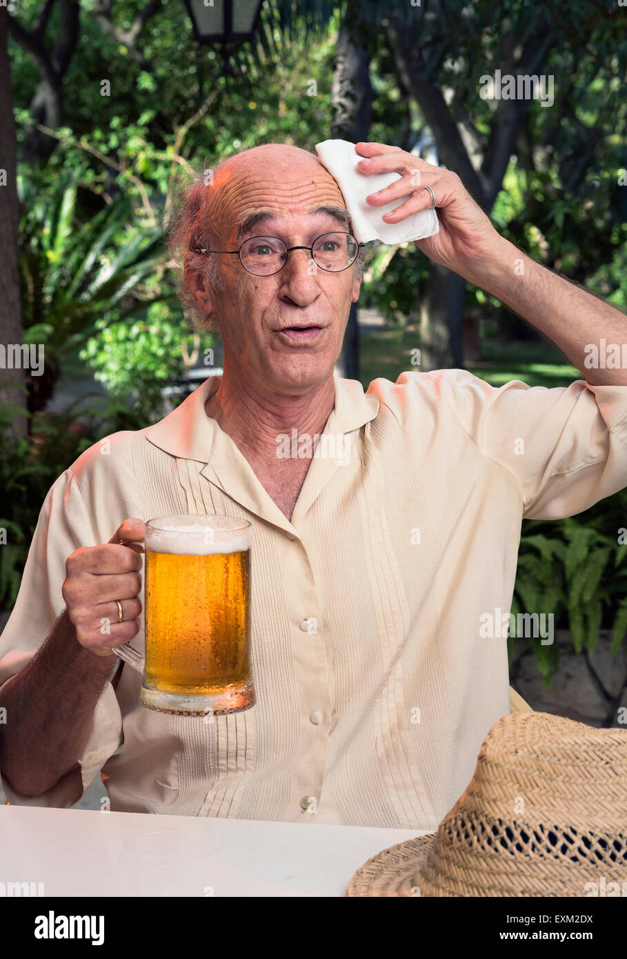 Homme plus âgé sur une chaude journée tenant une bière froide. Banque D'Images