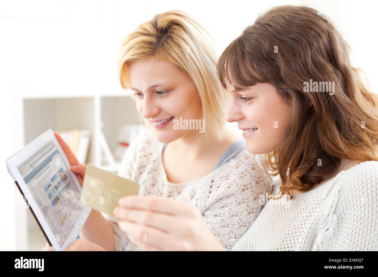 Voir des Filles de payer par carte de crédit sur leur Tablet Banque D'Images