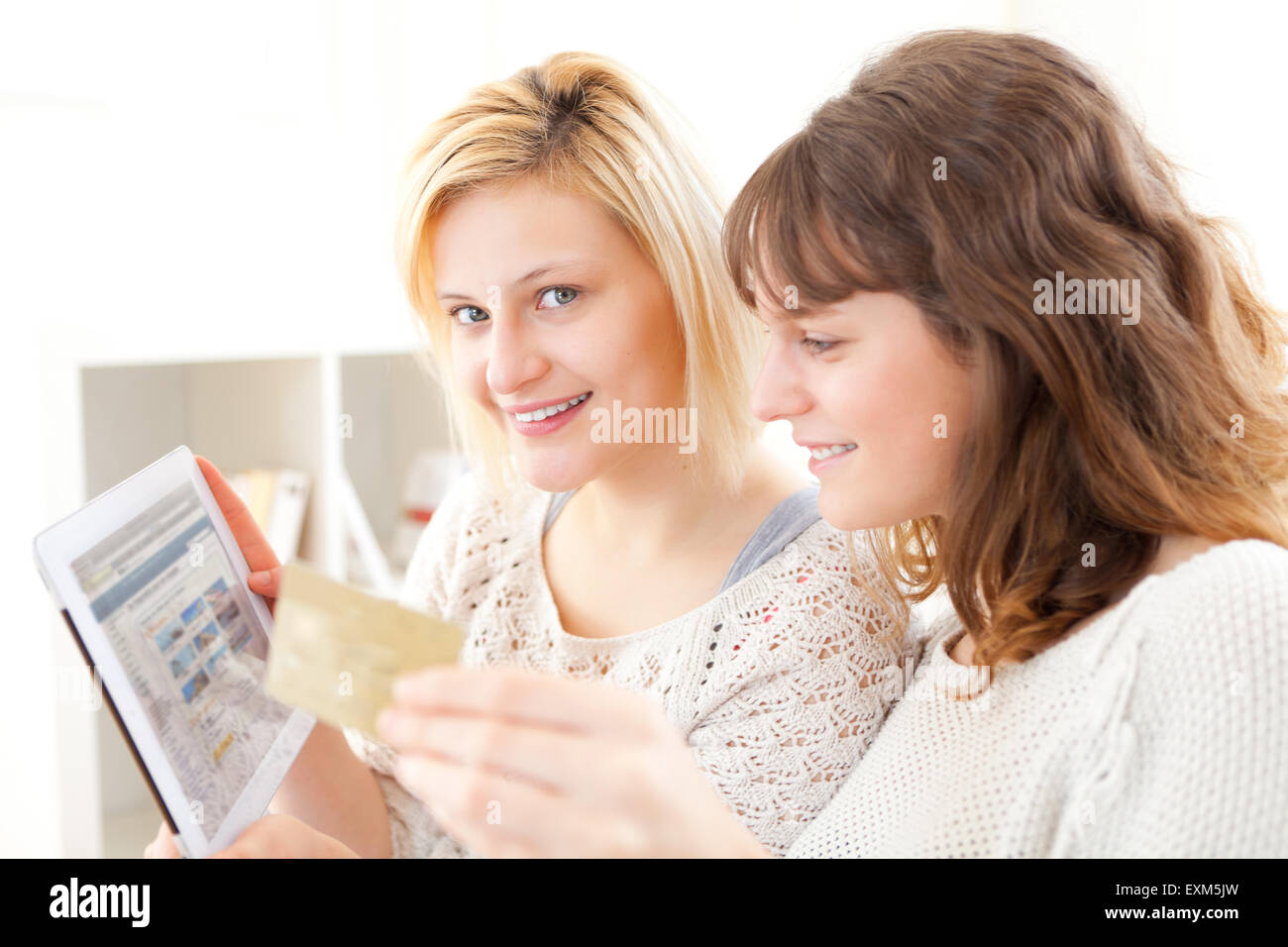 Voir des Filles de payer par carte de crédit sur leur Tablet Banque D'Images