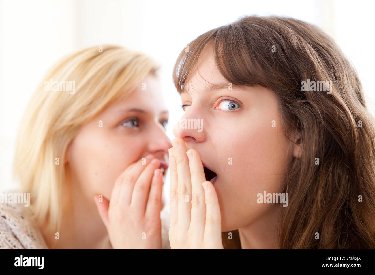 Avis de fille blonde de dire un secret à sa meilleure amie Banque D'Images