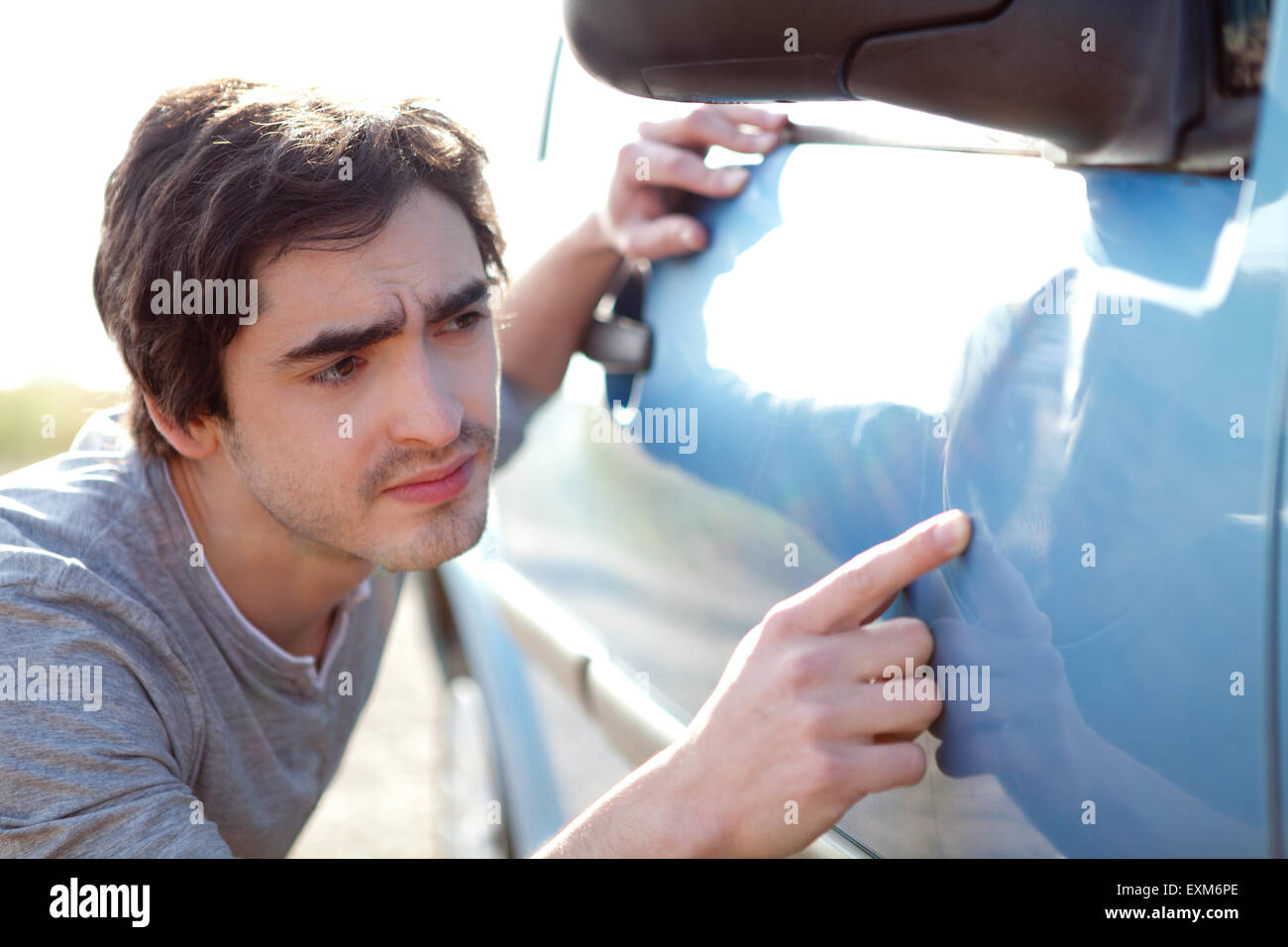 Vue d'un jeune homme à rayures sur sa voiture Banque D'Images