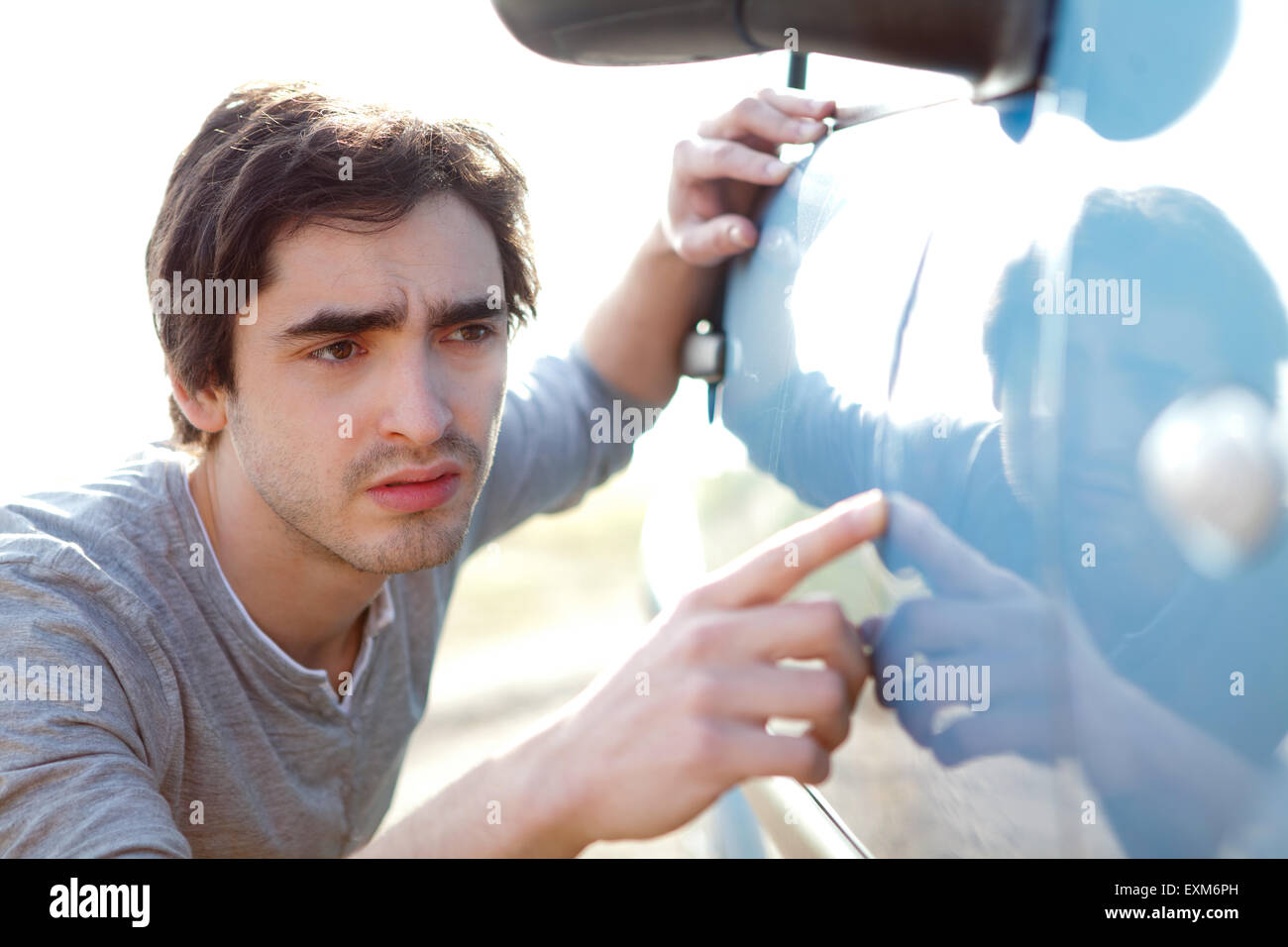 Vue d'un jeune homme à rayures sur sa voiture Banque D'Images