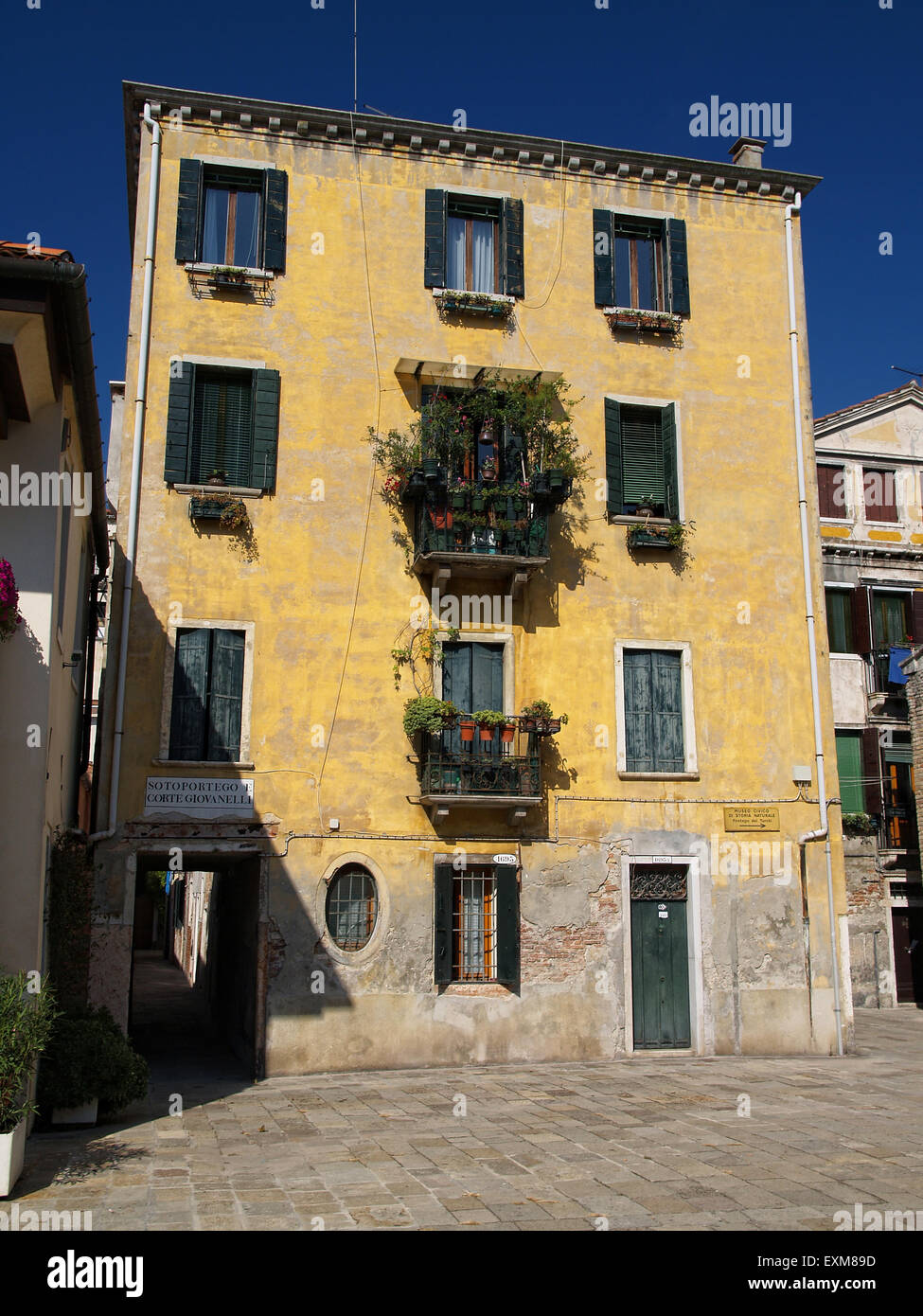 Vieille maison avec des fenêtres avec des volets verts à Venise, Italie. Banque D'Images