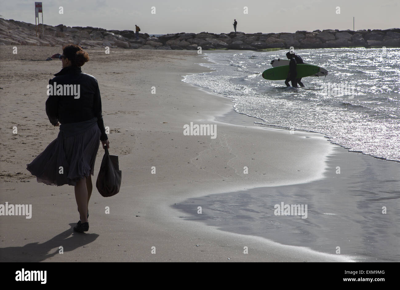 TEL AVIV, ISRAËL - 2 mars, 2015 : la silhouette de femme marchait et de surf sur la plage de Tel Aviv. Banque D'Images