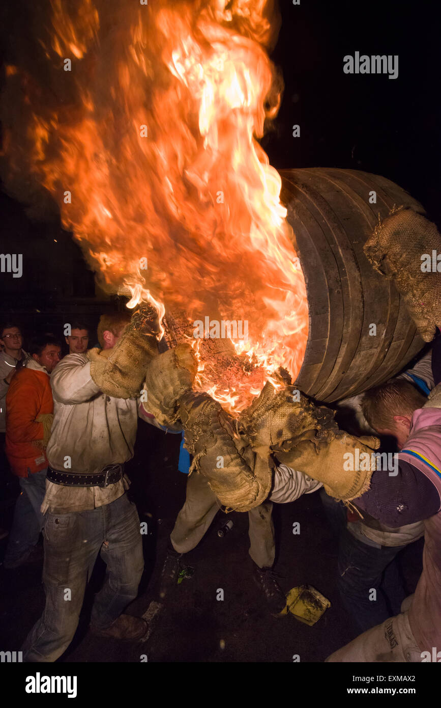 Grand men's barrel en cours sur la place pour marquer le Bonfire Night, 5 novembre, à la tar de barils festival, Honiton, Devon, Angleterre Banque D'Images