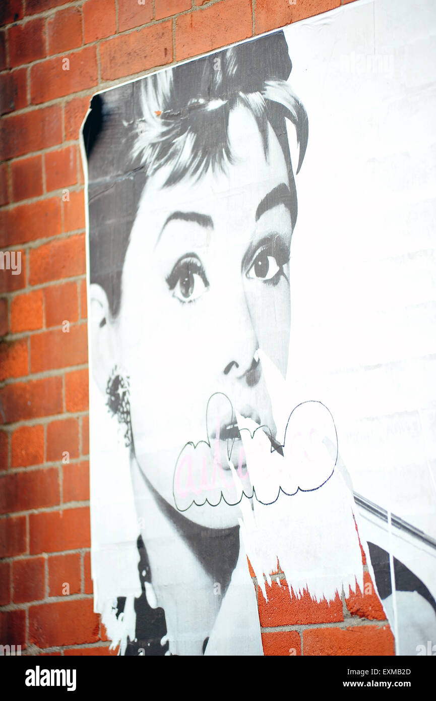 Un poster d'Audrey Hepburn avec un porte-cigarette dans un mur de brique à Dublin. Banque D'Images
