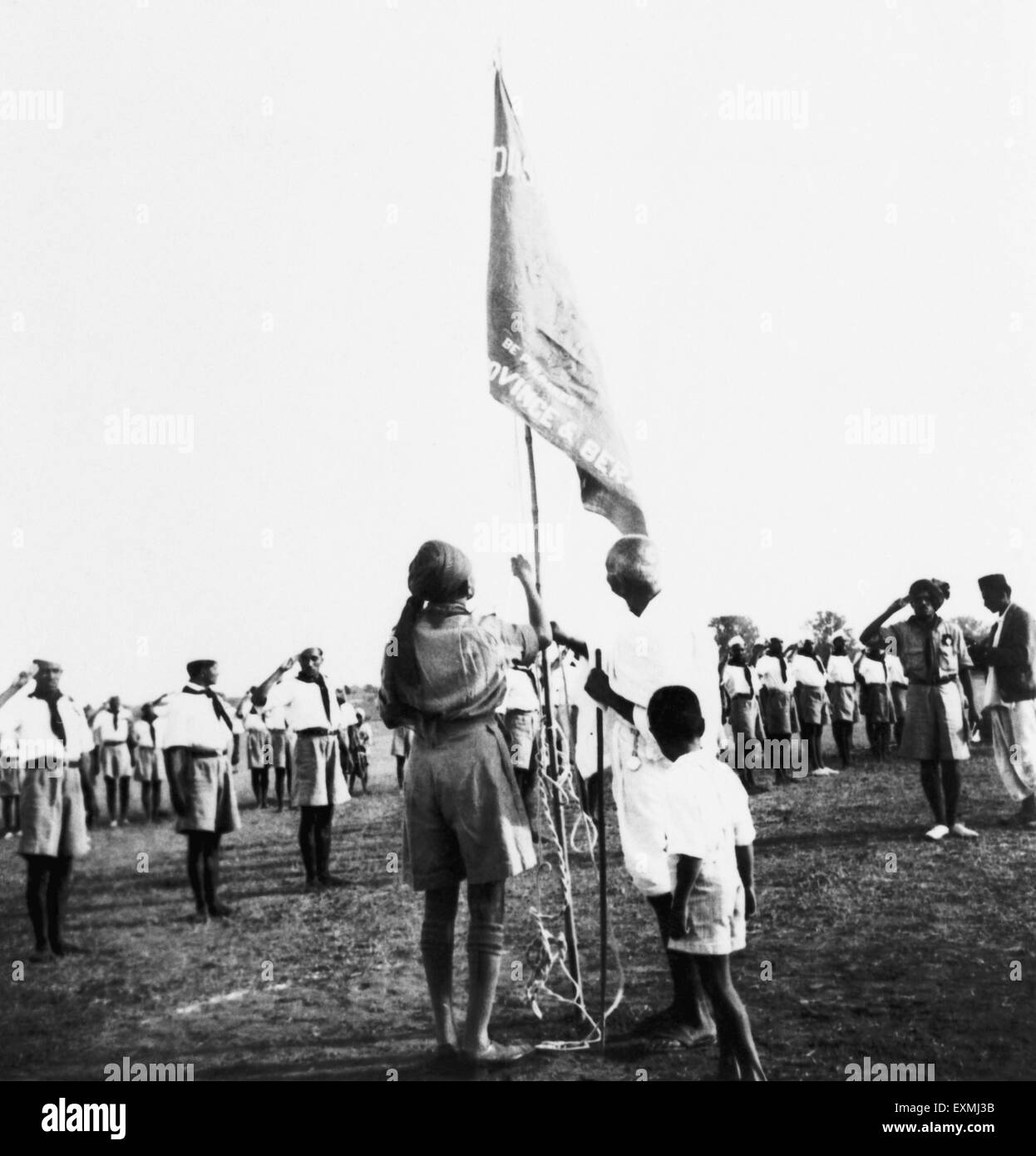 Mahatma Gandhi hissant un drapeau du Scoutisme ; vu par son petit-fils ; 1939 Kahandas PAS MR Banque D'Images