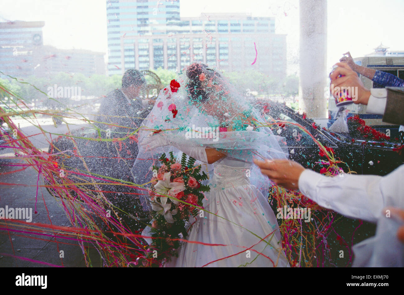 Une jeune mariée et se toilettent entrer dans un hôtel le jour de leur mariage ; Chine Banque D'Images