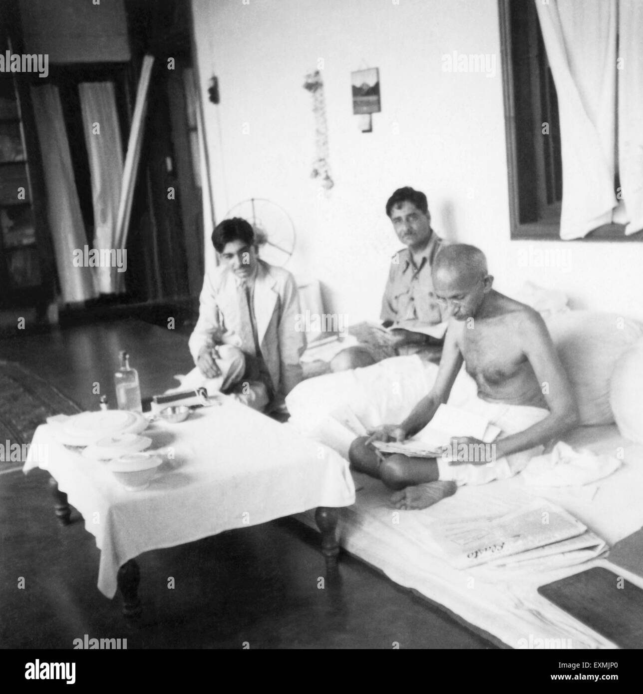 Mahatma Gandhi lisant avec deux visiteurs, 1938, Inde, Asie, ancienne image millésime 1900 Banque D'Images