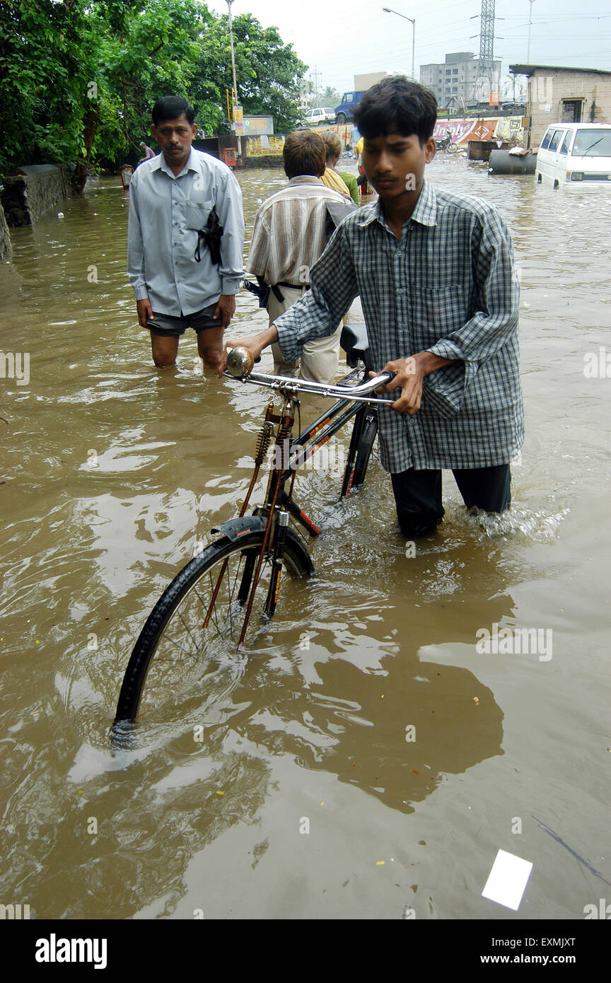 Inondations de pluie de mousson, homme poussant vélo, Bombay, Mumbai, Maharashtra, Inde, Asie Banque D'Images