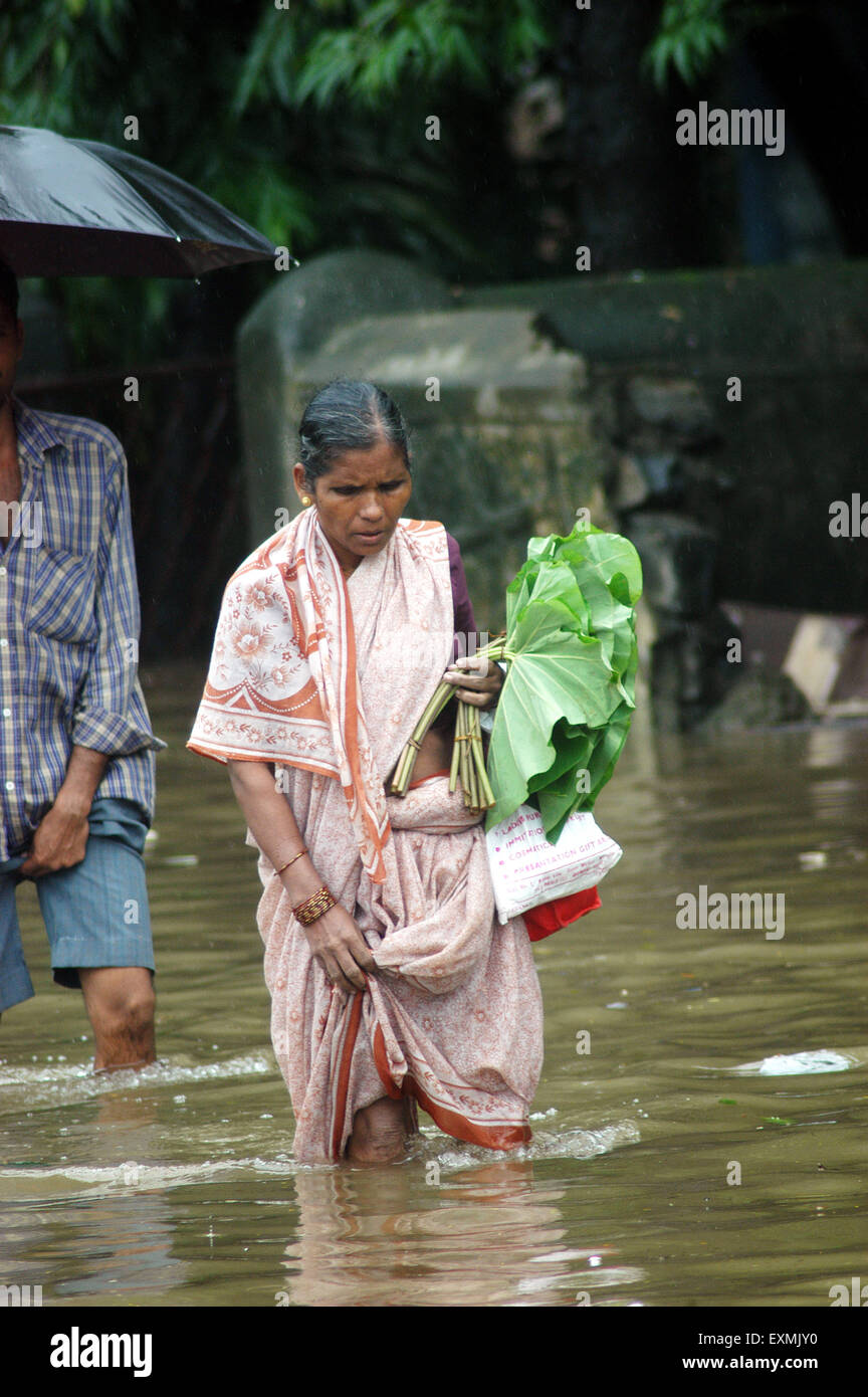 Inondations dues à la mousson, femme marchant dans une rue inondée, Bombay, Mumbai, Maharashtra, Inde, Asie Banque D'Images