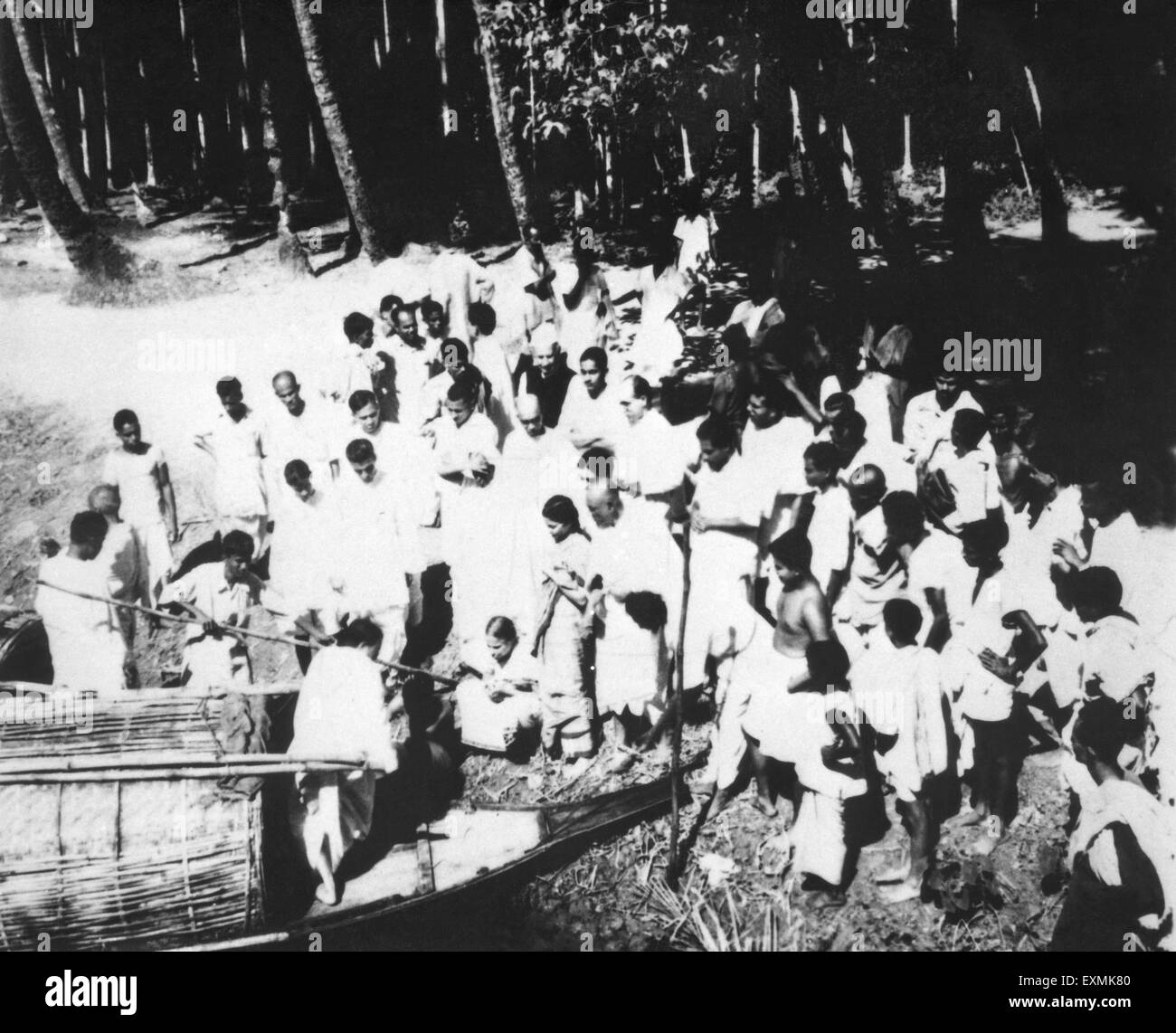 Les gens debout à côté d'un bateau à Noakhali du Bengale oriental ; après les émeutes entre hindous et musulmans Banque D'Images