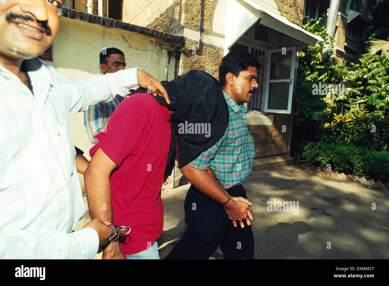 visage couvert masque cagoule homme criminel pris escorté police bombay mumbai maharashtra inde asie Banque D'Images