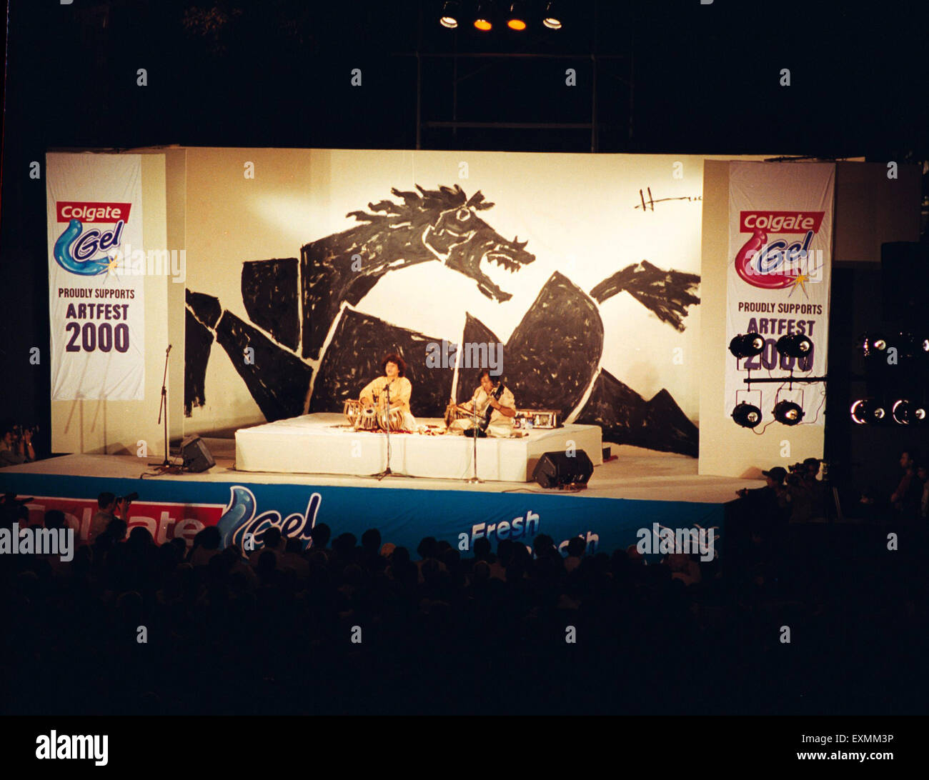 Musique classique indienne maestro Ustad Zakir Hussain jouant de la tabla en concert ci-dessous de la peinture de cheval par M F Husain Artfest Mumbai Inde Asie Banque D'Images