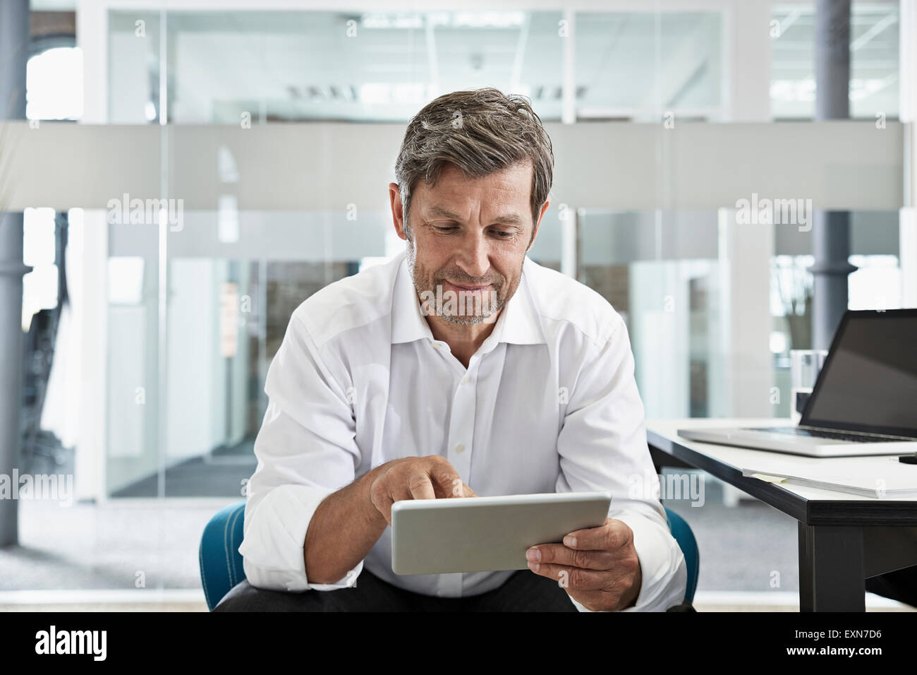 Businessman in office looking at digital tablet Banque D'Images