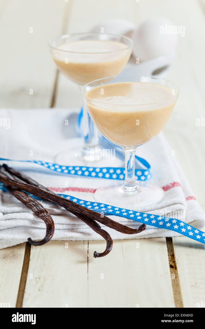 Deux verres de liqueur d'oeuf, vanille et ruban sur le chiffon Banque D'Images