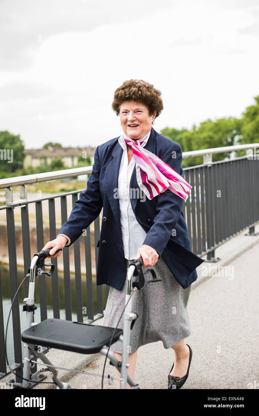 Young woman walking with wheeled walker Banque D'Images