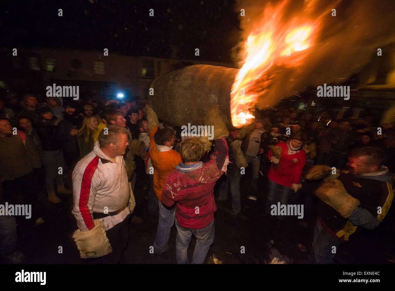 Grand men's barrel en cours au travers des foules sur la place pour marquer le Bonfire Night, 5 novembre, à la tar de barils festival, Honiton, Devon, Angleterre Banque D'Images