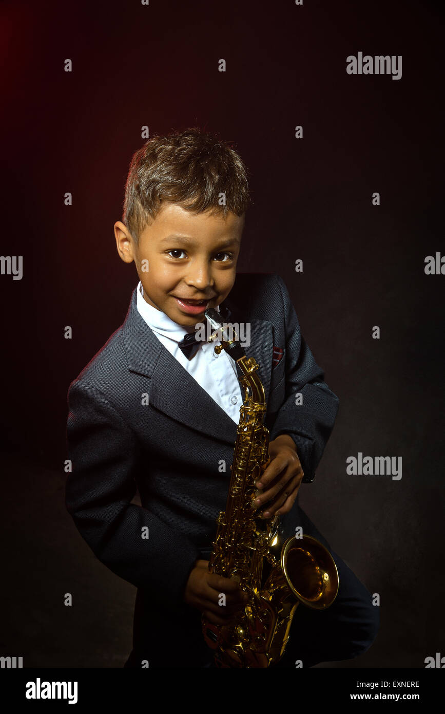 Un garçon de six ans avec sourire et saxophone Banque D'Images