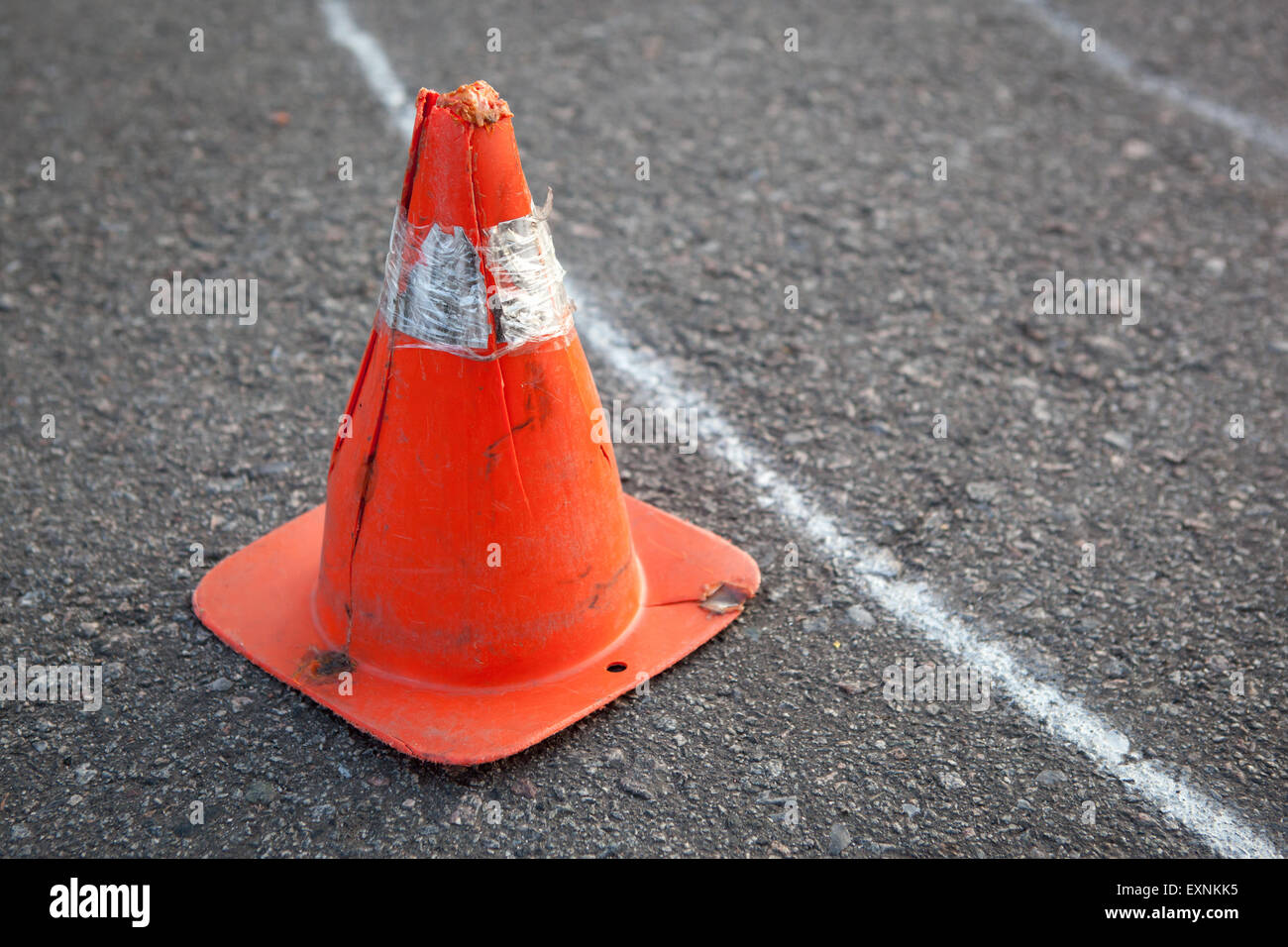 Vieux cône rayé orange sur route - concept auto-école de droit. Banque D'Images