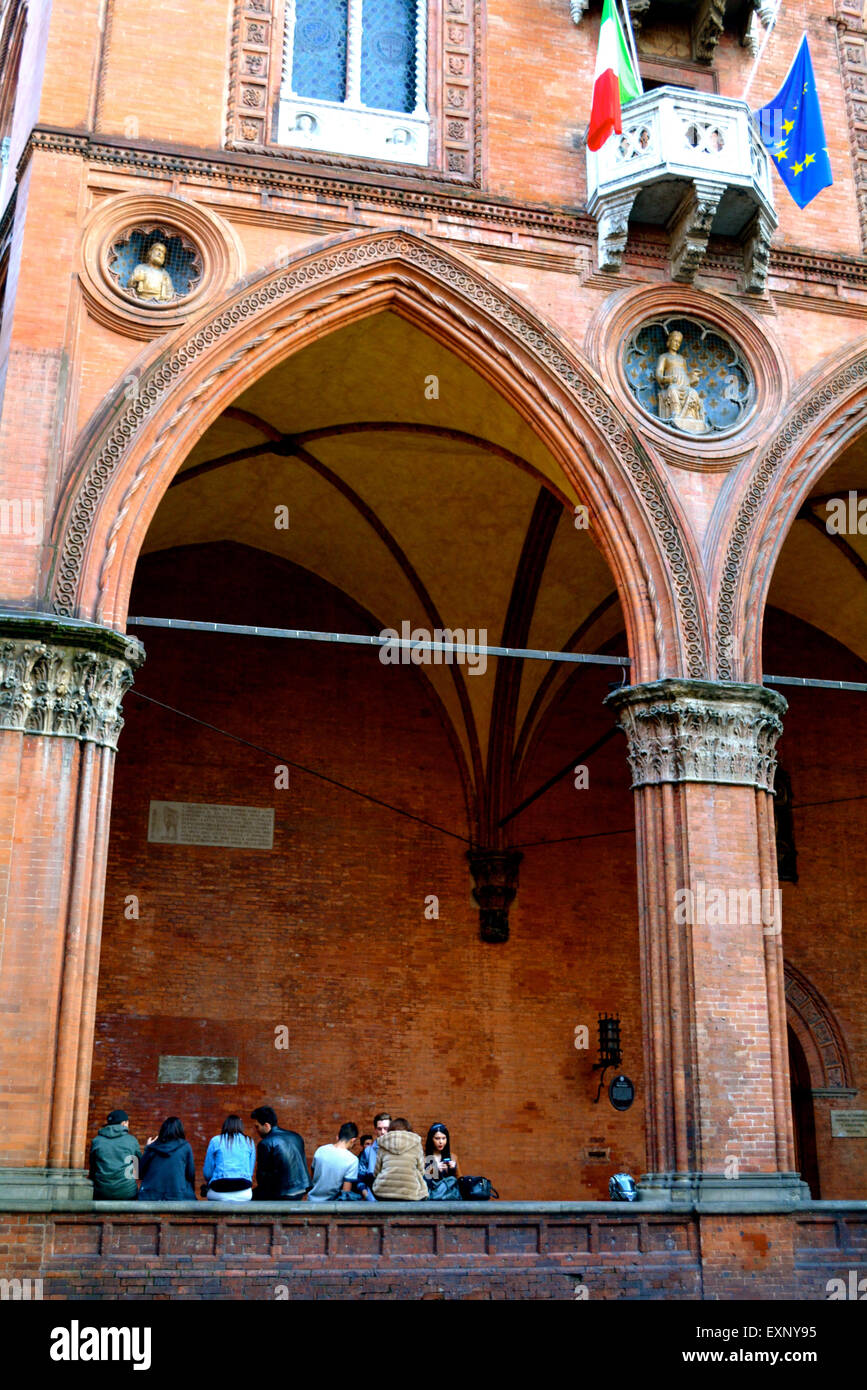 Un groupe d'étudiants assis sous un grand porche à Bologne, Italie Banque D'Images