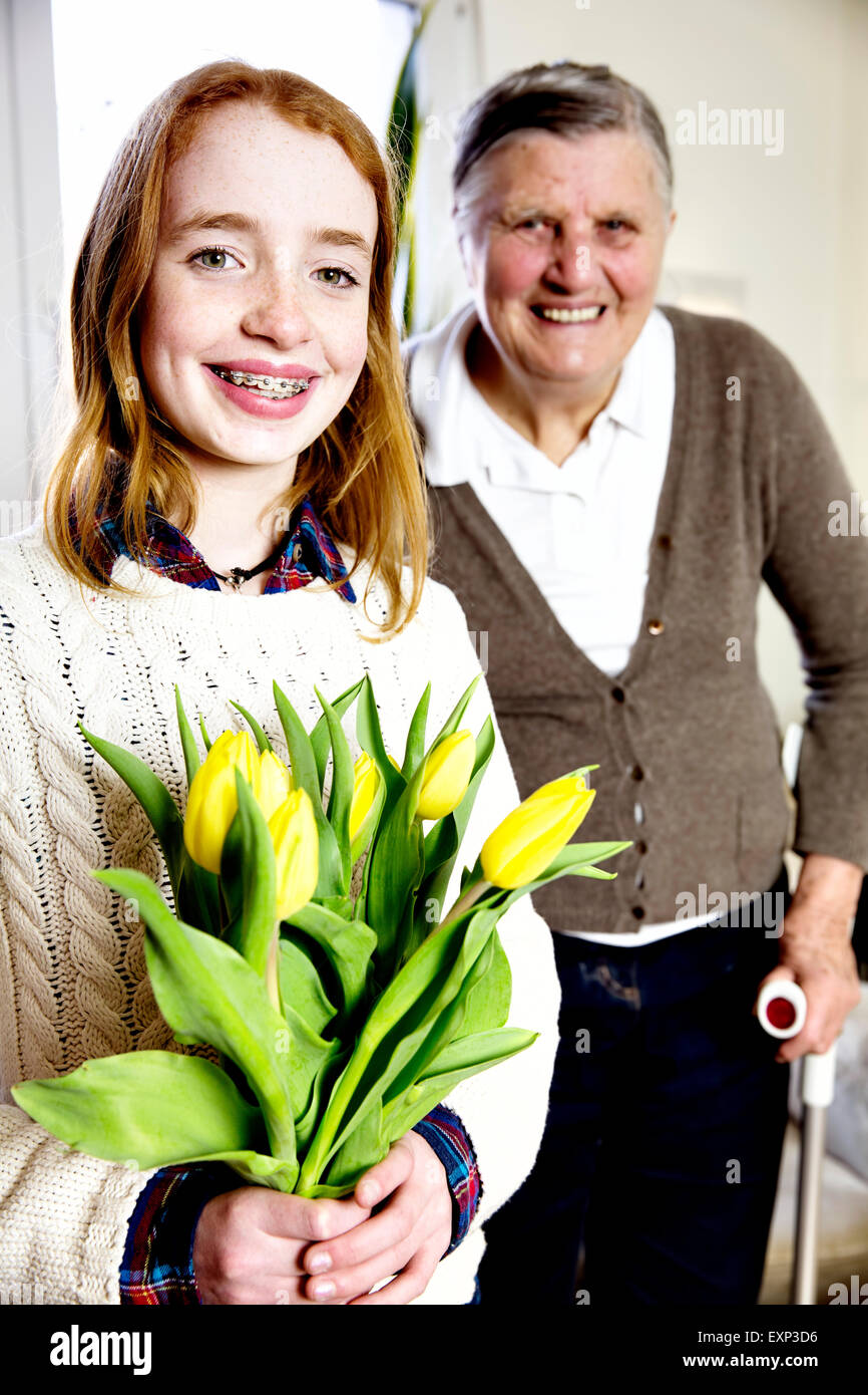 Petite-fille avec un bouquet de fleurs avec sa grand-mère, Allemagne Banque D'Images