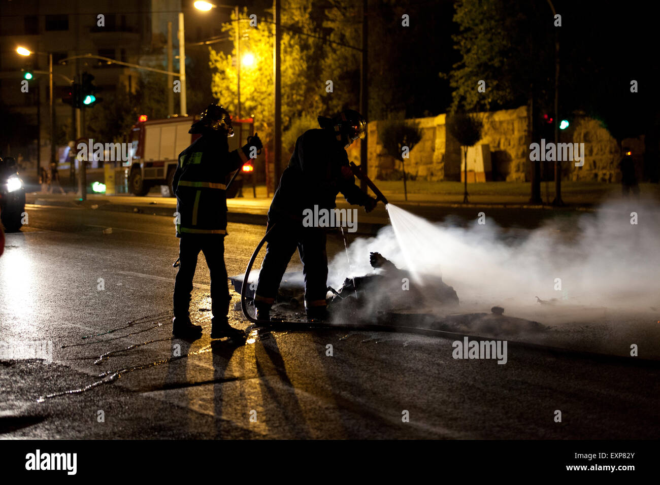 Athènes, Grèce. 15 juillet, 2015. Fireman distinguer les dommages causés par les anarchistes au cours de la lutte contre les manifestations d'austérité à Athènes alors que le 3e vote de renflouement est discuté au parlement grec. Crédit : Martin Garnham/Alamy Live News Banque D'Images