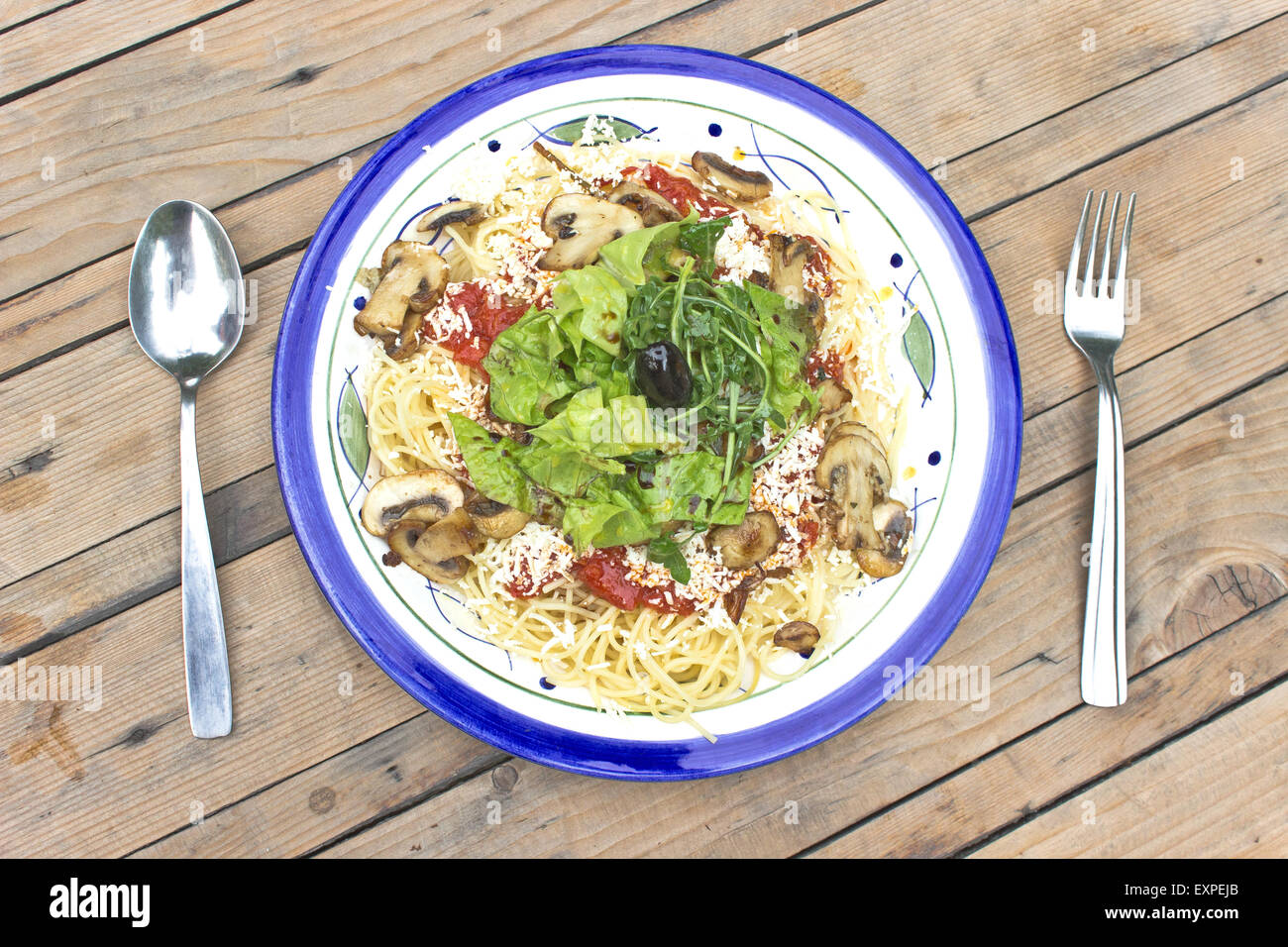 Spaghetti aux champignons et herbe verte sur fond de bois Banque D'Images