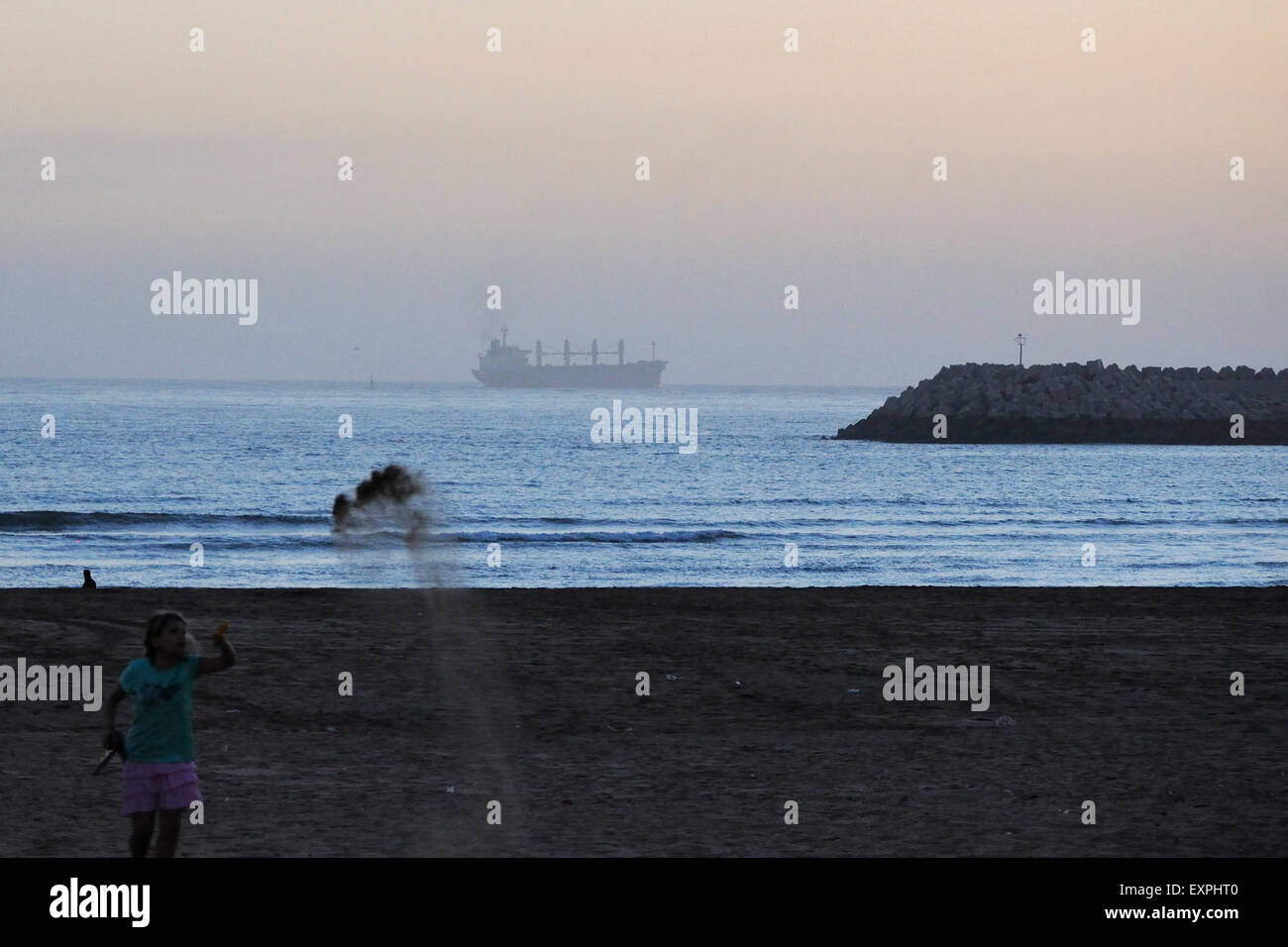 Fille jouant avec le sable à la plage à Agadir. Banque D'Images