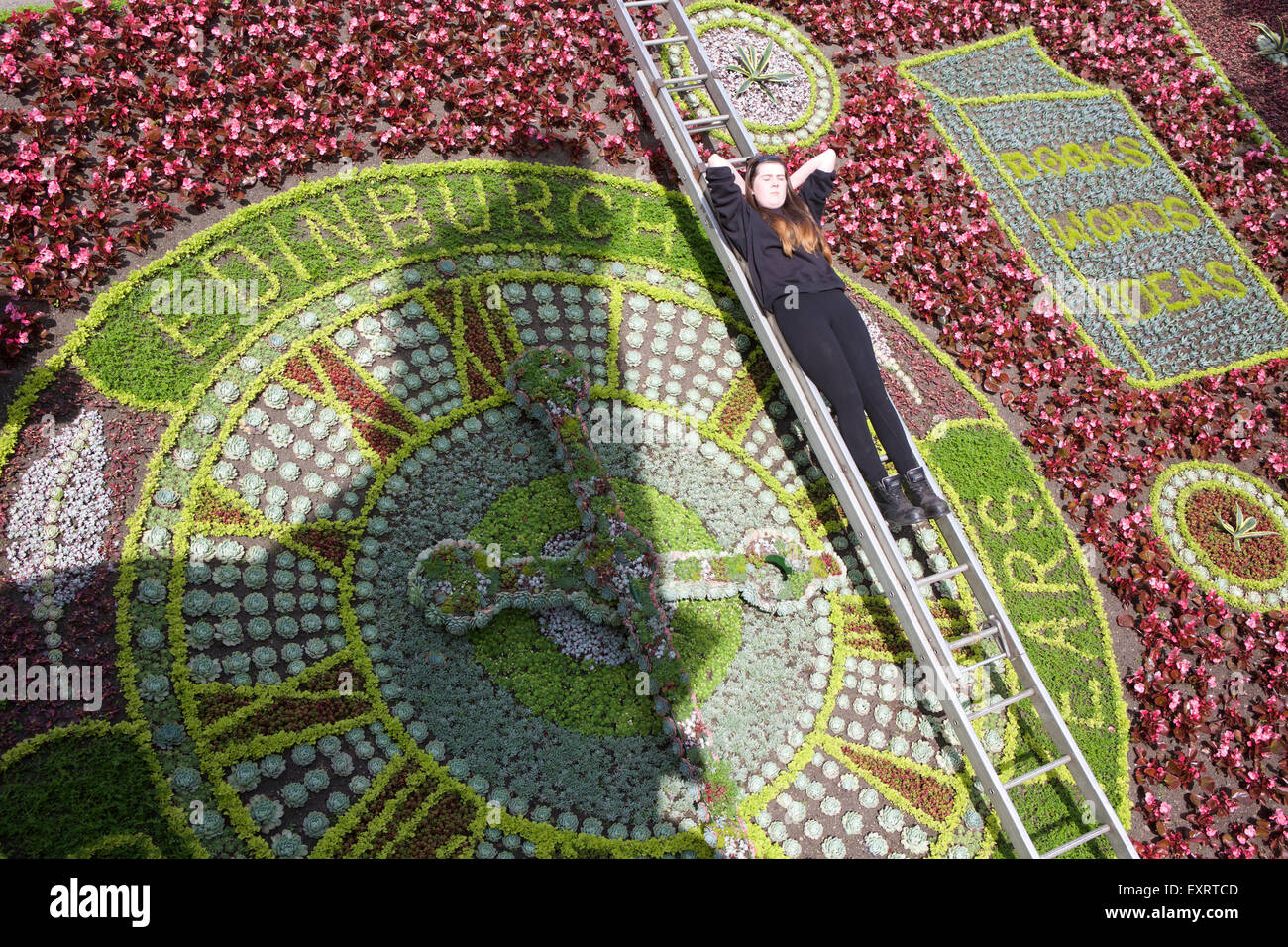Edinburgh, Ecosse, Royaume-Uni. 16 juillet, 2015. L'horloge florale dans les jardins de Princes Street a été révélé aujourd'hui, qui fête cette année dix ans d'Edimbourg comme Ville UNESCO de la littérature. La célèbre horloge prend plus de cinq semaines pour créer et dispose d'un thème différent chaque année. Le premier a été planté en 1903 et au cours des années, elle a été inspiré par des thèmes tels que Robert Louis Stevenson, le centenaire de la décennie comme une ville du commerce équitable et de la reine Elizabeth II Coronation. Sur la photo : Gillian Denny, crédit 19 : Richard Dyson/Alamy Live News Banque D'Images