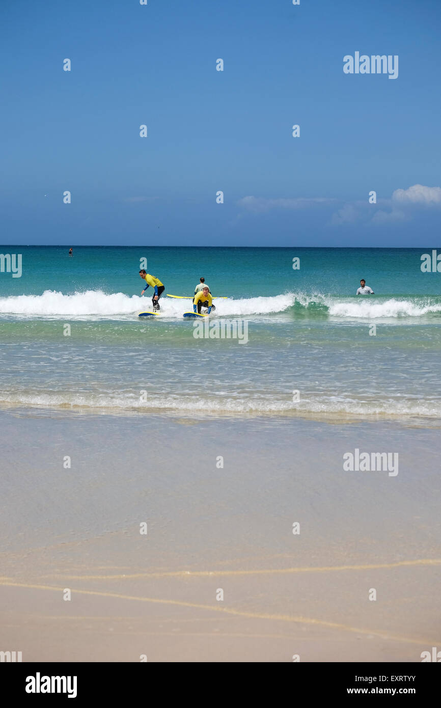 St Ives, Cornwall, UK : groupe de personnes apprendre à surfer au large de Porthmeor Beach à St Ives en Cornouailles. Banque D'Images