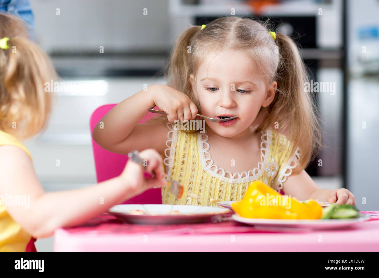 Les petits enfants de manger de la nourriture à la garderie Banque D'Images